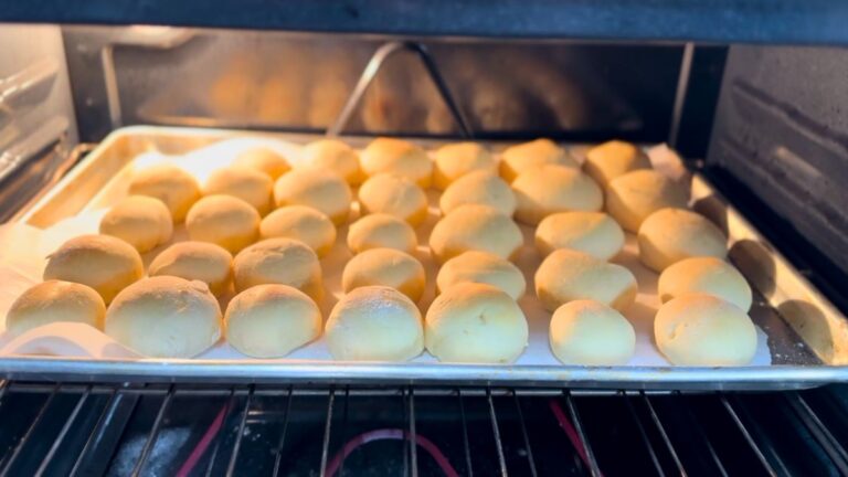 Tray of homemade rolls baking in the oven with a soft golden finish