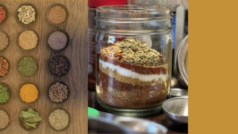 Glass jar filled with layers of spices for taco seasoning beside an array of herbs and seeds