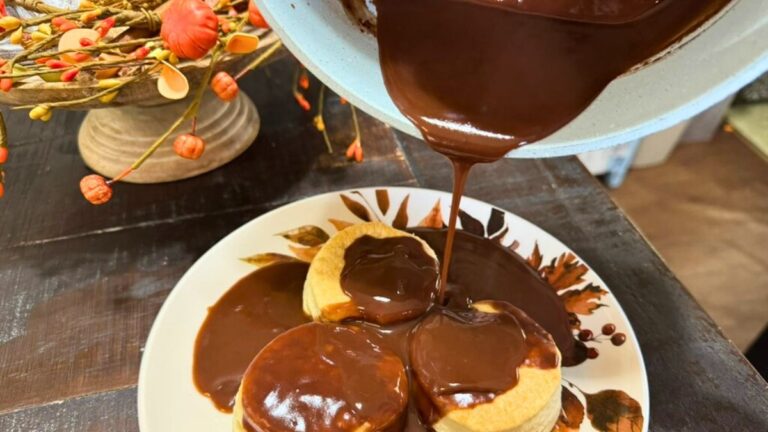 Chocolate gravy being poured over biscuits on a fall-themed plate