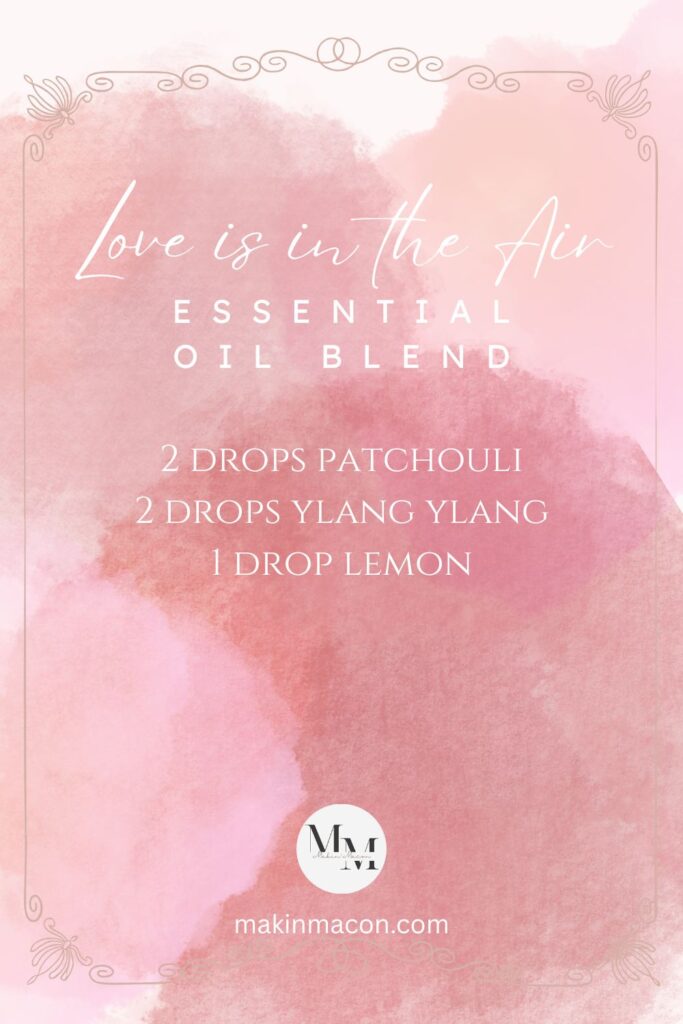 Pink watercolor background featuring the Love is in the Air essential oil blend recipe with drops of patchouli, ylang ylang, and lemon.
