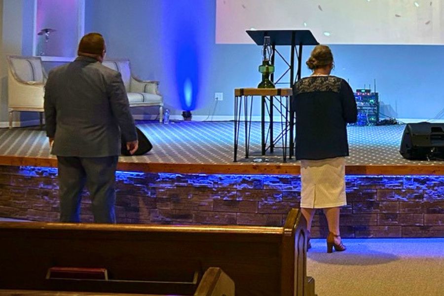Couple standing in church praying during ministry service