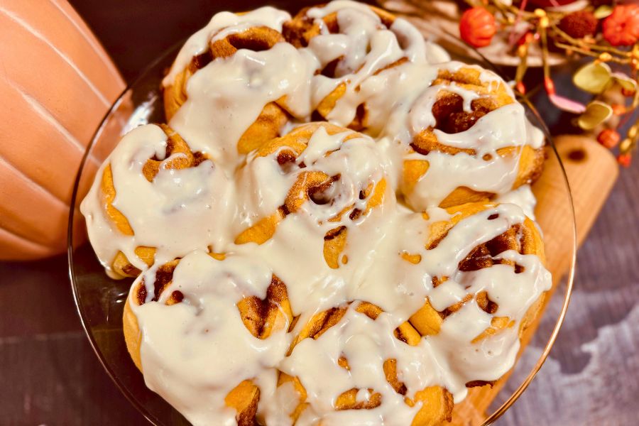 Sourdough pumpkin cinnamon rolls with icing on top, warm and homemade fall treat