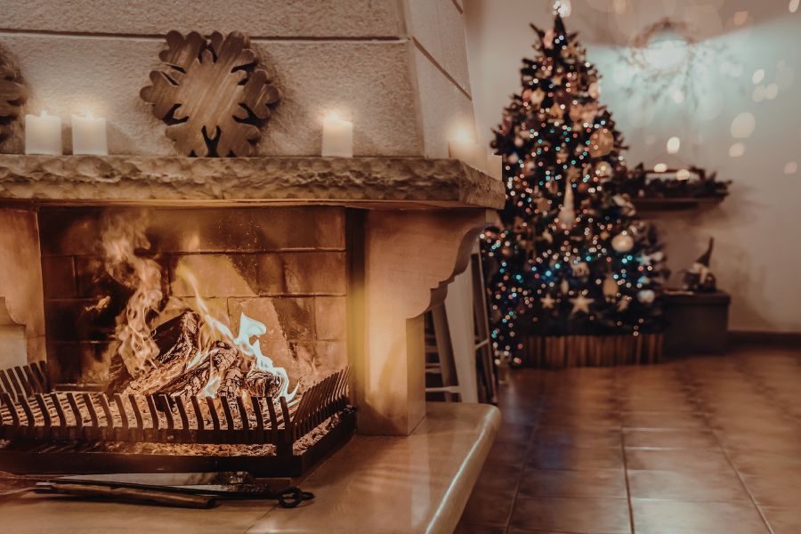 Cozy holiday fireplace with Christmas tree creating a warm and festive home atmosphere