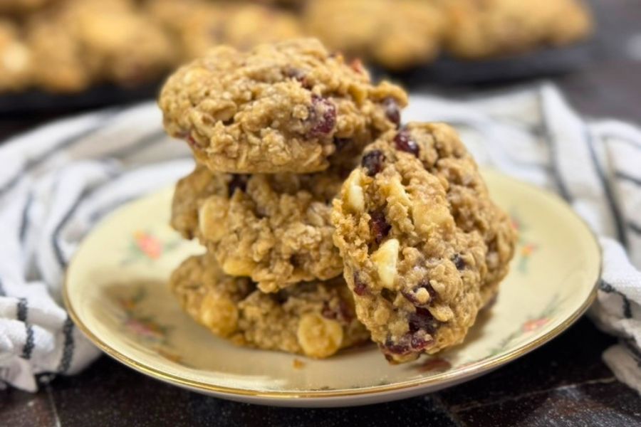 White chocolate cranberry oatmeal cookies stacked on a plate for a festive holiday treat