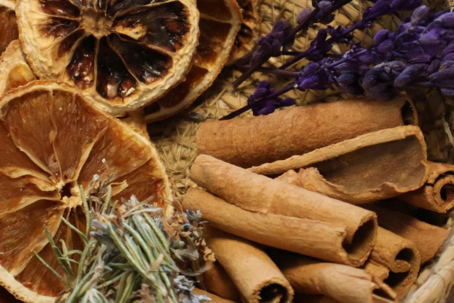 Dried oranges, cinnamon sticks, and lavender arranged for a peaceful essential oil blend