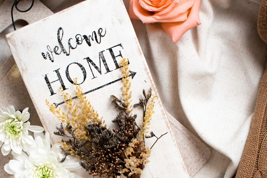 Welcome home sign with flowers and cozy decor representing love and a warm inviting home