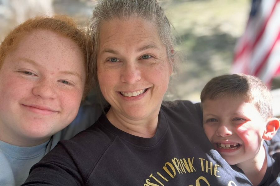 Homeschooling mom smiling with her two children during a relaxed learning moment at home
