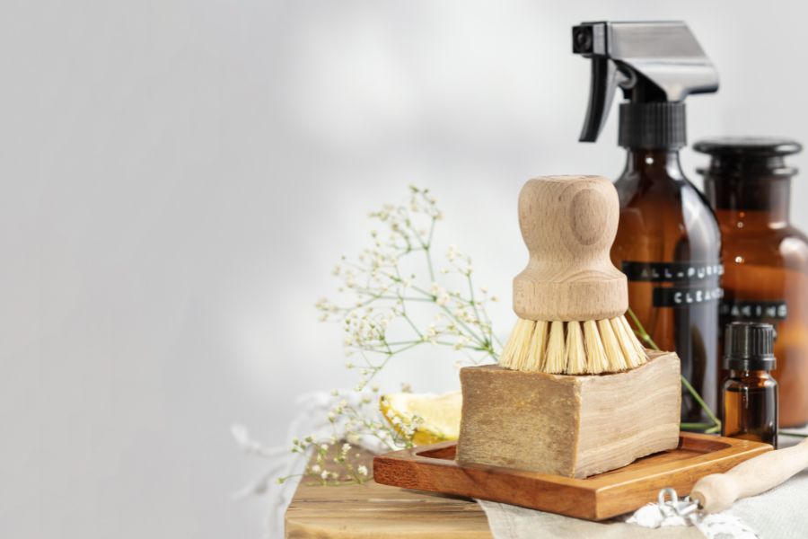 Spring renewal essential oils blend with natural cleaning supplies and amber glass bottles on a wooden tray