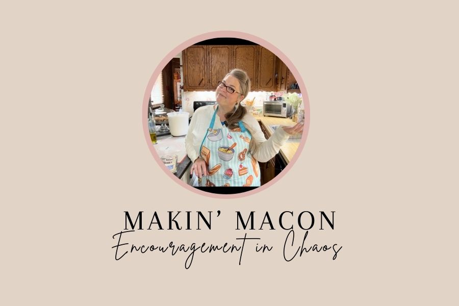Susan Raynor smiling in the kitchen with a playful baking apron — host of Makin’ Macon: Encouragement in Chaos podcast.