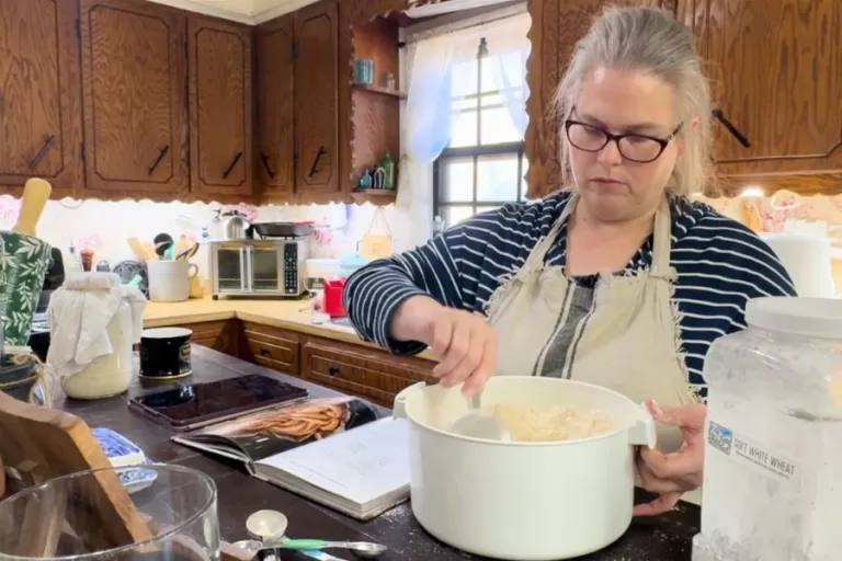 Susan measuring fresh milled soft white wheat while learning how to convert recipes to fresh milled flour in her home kitchen.