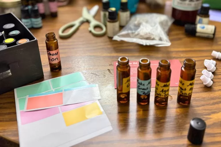 essential oil roller bottles and blending supplies on a table while making homemade essential oil blends