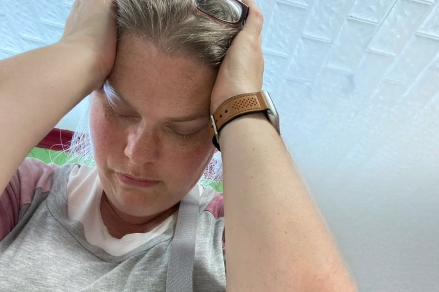 Woman holding her head in frustration and overwhelm, representing subtle spiritual attacks and losing peace in everyday life