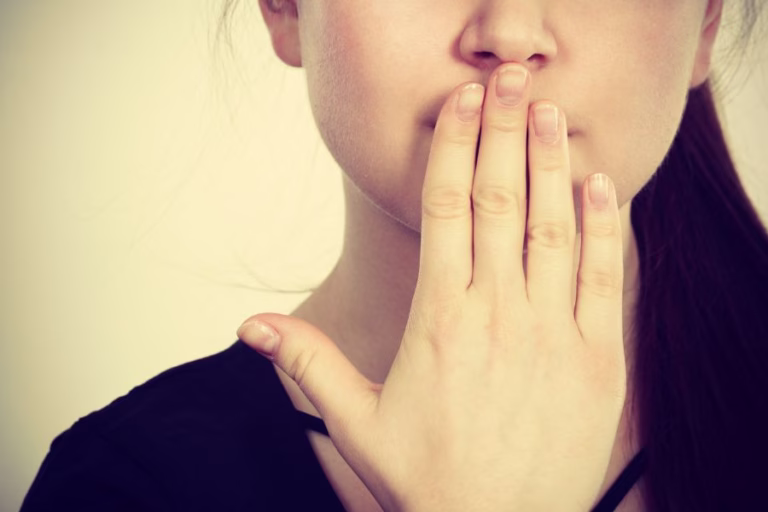 Woman covering her mouth reflecting on words and Christian character, representing guarding your heart and speech