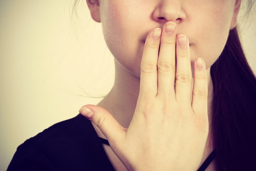 Woman covering her mouth reflecting on words and Christian character, representing guarding your heart and speech