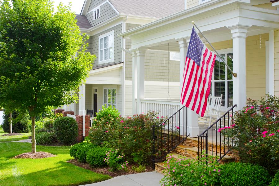 Front porch with rocking chairs and an American flag representing natural bug repellent spray for summer porch evenings and outdoor gatherings