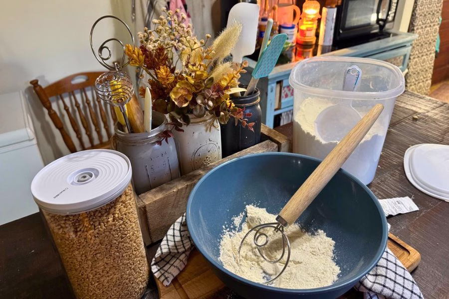 Fresh milled flour and hard white wheat berries prepared for homemade bread baking in a busy family kitchen